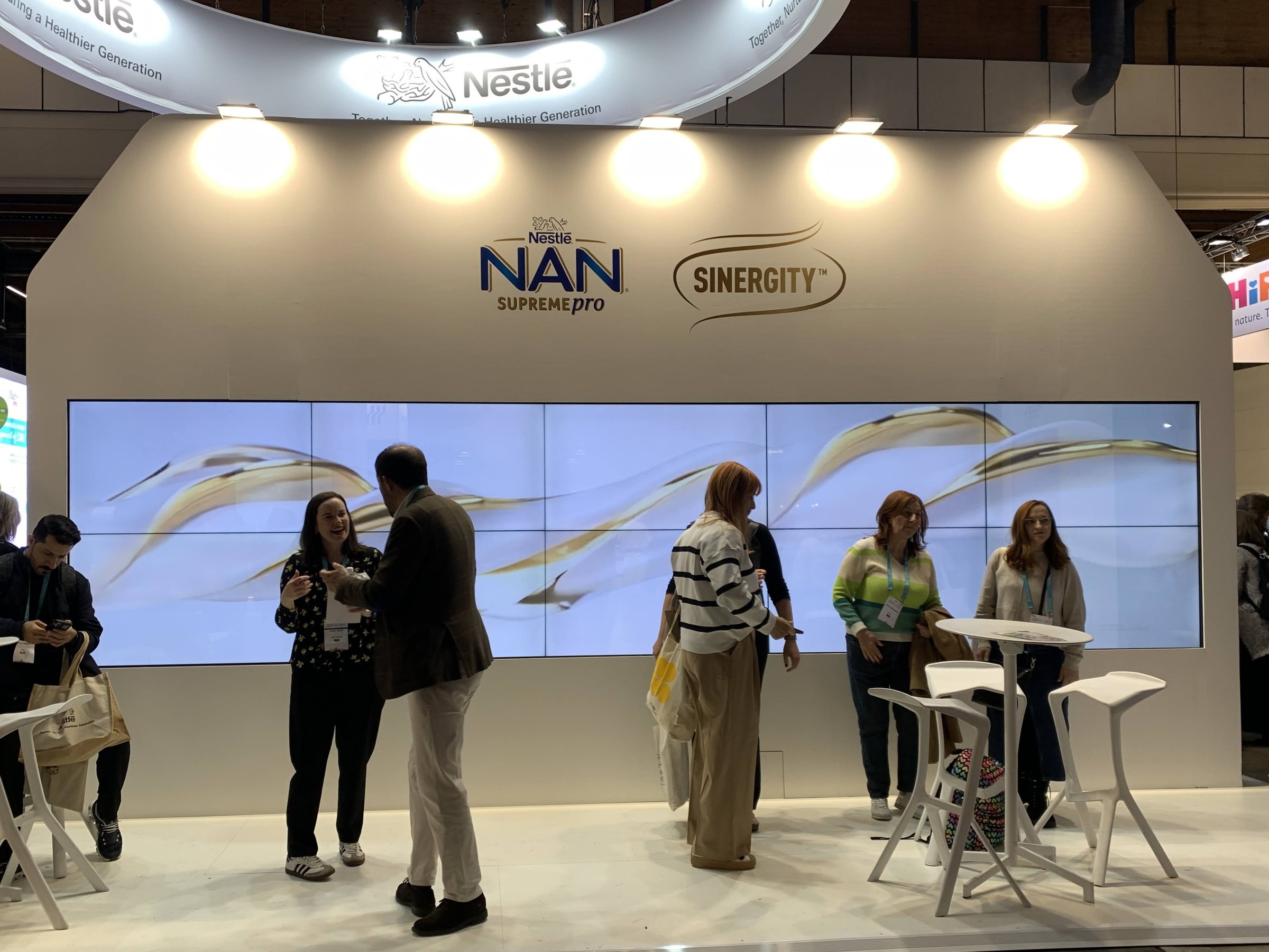 Nestlé stand at ESPGHAN 2025 seen from the aisle, with the product wall and seating